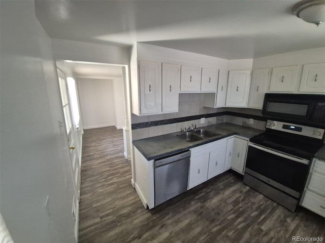 588 Empire St, Aurora, CO 80010 - kitchen with appliances with stainless steel finishes, a sink, dark countertops, white cabinetry, and dark wood-style floors