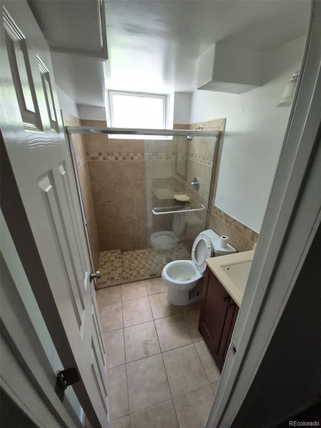 588 Empire St, Aurora, CO 80010 - full bath featuring toilet, vanity, a stall shower, and tile patterned flooring