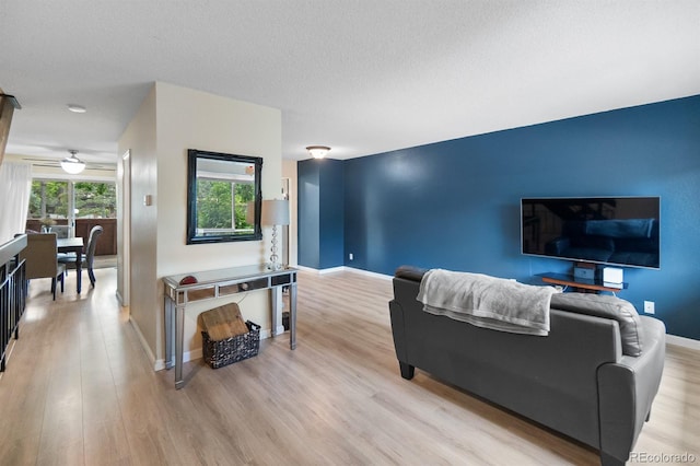6856 S Broadway, Centennial, CO 80122 - living room featuring baseboards, light wood-style flooring, and a textured ceiling