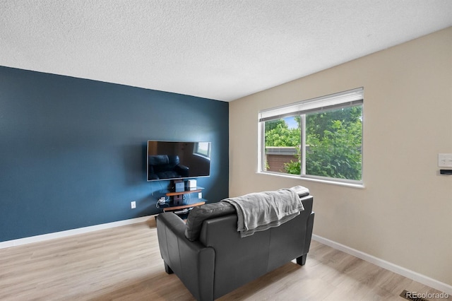 6856 S Broadway, Centennial, CO 80122 - living area with light wood-type flooring, baseboards, and a textured ceiling