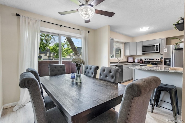 6856 S Broadway, Centennial, CO 80122 - dining area with light wood-style floors, ceiling fan, a textured ceiling, and baseboards