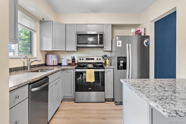 6856 S Broadway, Centennial, CO 80122 - kitchen with appliances with stainless steel finishes, gray cabinets, light wood-style floors, and a sink