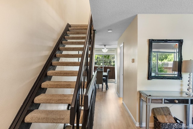 6856 S Broadway, Centennial, CO 80122 - staircase featuring wood finished floors, baseboards, a textured ceiling, and a ceiling fan