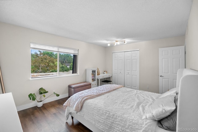 6856 S Broadway, Centennial, CO 80122 - bedroom featuring baseboards, dark wood-type flooring, a closet, and a textured ceiling