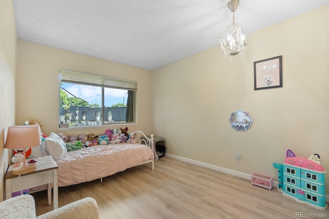 6856 S Broadway, Centennial, CO 80122 - bedroom with wood finished floors, baseboards, and a chandelier