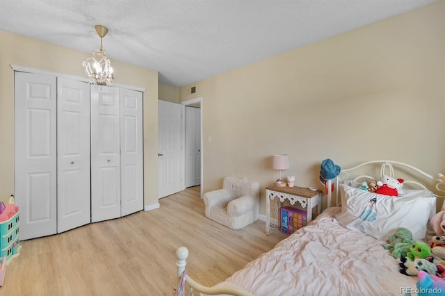 6856 S Broadway, Centennial, CO 80122 - bedroom with a chandelier, wood finished floors, baseboards, a closet, and a textured ceiling