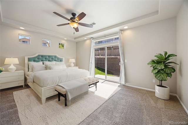 bedroom featuring access to outside, carpet flooring, a tray ceiling, and ceiling fan