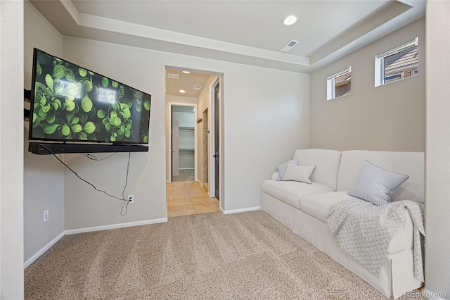 living area with light carpet and a tray ceiling