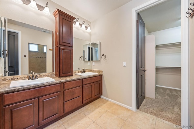 bathroom with tile patterned floors, a shower, and vanity