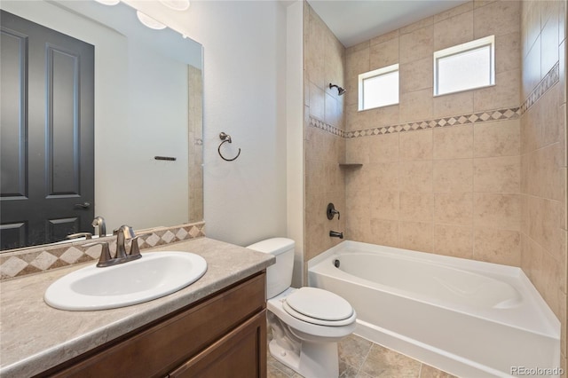 full bathroom with tile patterned flooring, vanity, toilet, and tiled shower / bath