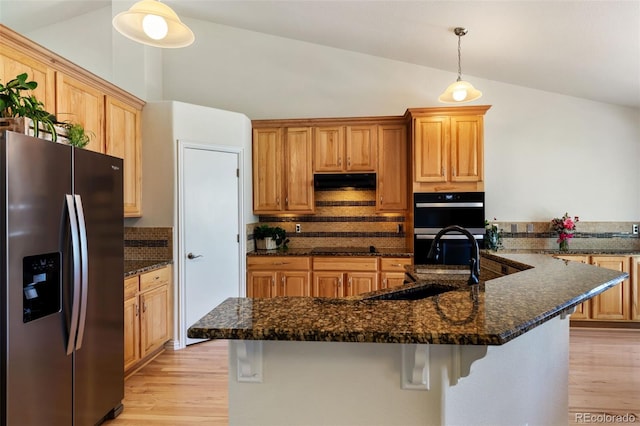 4143 Eagle Ridge Way, Castle Rock, CO 80104 - kitchen with appliances with stainless steel finishes, lofted ceiling, light wood-style floors, backsplash, and under cabinet range hood