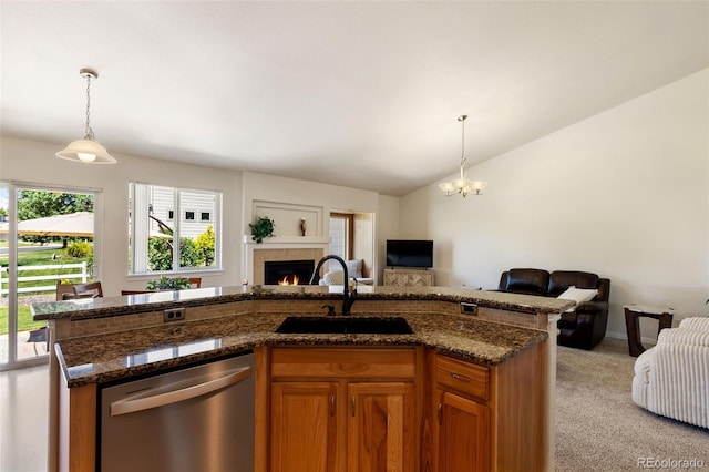 4143 Eagle Ridge Way, Castle Rock, CO 80104 - kitchen featuring stainless steel dishwasher, open floor plan, a warm lit fireplace, brown cabinets, and light carpet