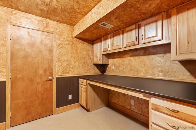 4143 Eagle Ridge Way, Castle Rock, CO 80104 - kitchen with built in desk, concrete floors, and wainscoting