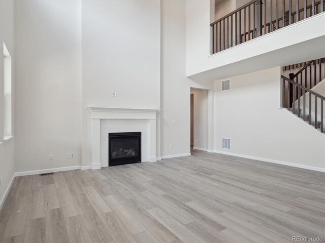 4741 Twelve Oaks Way, Castle Rock, CO 80104 - unfurnished living room featuring a high ceiling, wood finished floors, stairway, a glass covered fireplace, and baseboards