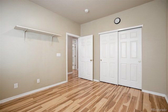 unfurnished bedroom with a closet, light wood-type flooring, and baseboards