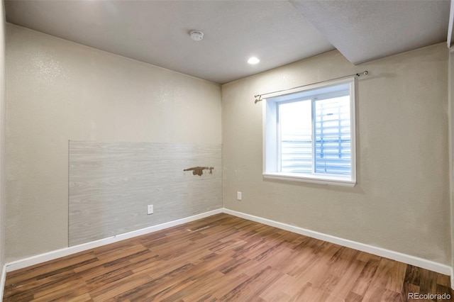 spare room with wood finished floors and baseboards