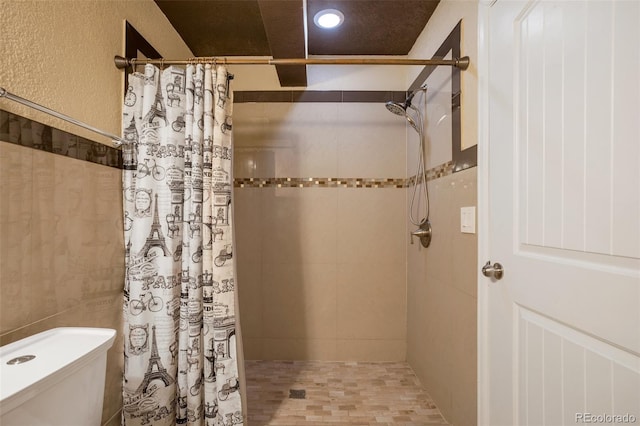 bathroom featuring toilet and tiled shower