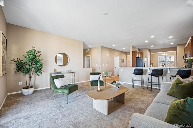 living room with an inviting chandelier and light carpet