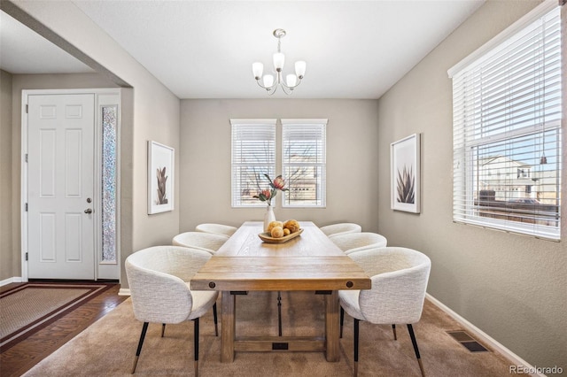 dining room with hardwood / wood-style floors and a chandelier