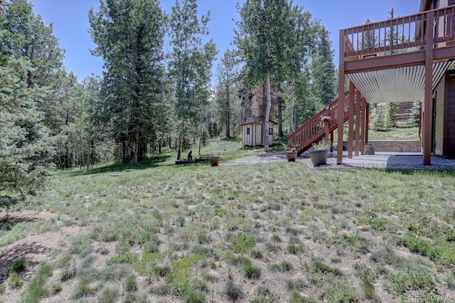 10438 Sunlight Ln, Conifer, CO 80433 - view of yard featuring a storage shed, a wooden deck, and stairs