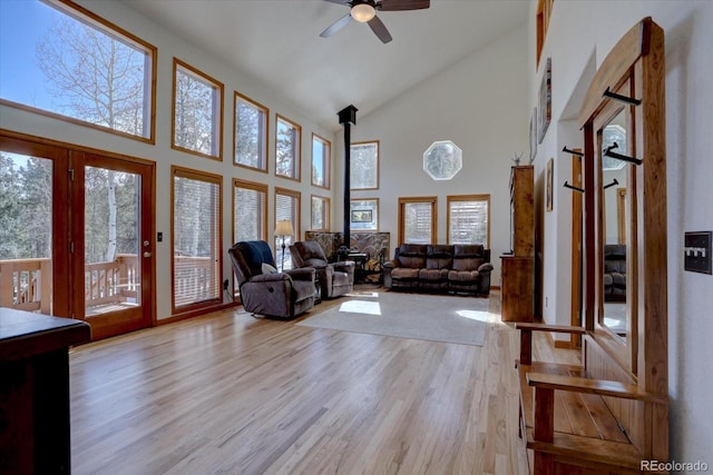 10438 Sunlight Ln, Conifer, CO 80433 - living room featuring high vaulted ceiling, a ceiling fan, light wood-type flooring, and a wood stove