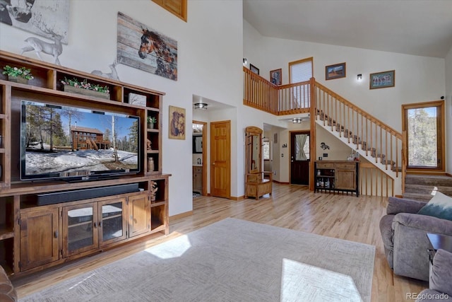 10438 Sunlight Ln, Conifer, CO 80433 - living room featuring stairway, light wood-type flooring, and high vaulted ceiling