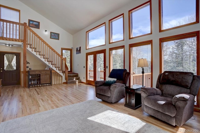 10438 Sunlight Ln, Conifer, CO 80433 - living area featuring high vaulted ceiling, wood finished floors, stairs, and healthy amount of natural light