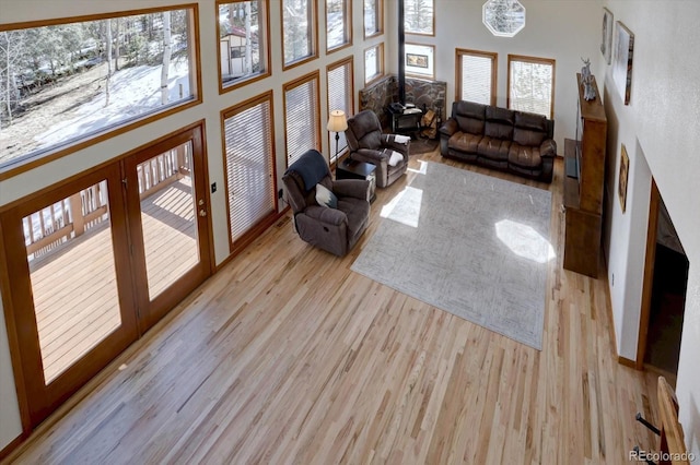 10438 Sunlight Ln, Conifer, CO 80433 - living area featuring wood finished floors, a wood stove, french doors, and a high ceiling