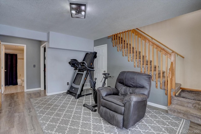 10438 Sunlight Ln, Conifer, CO 80433 - sitting room featuring stairs, wood finished floors, and a textured ceiling