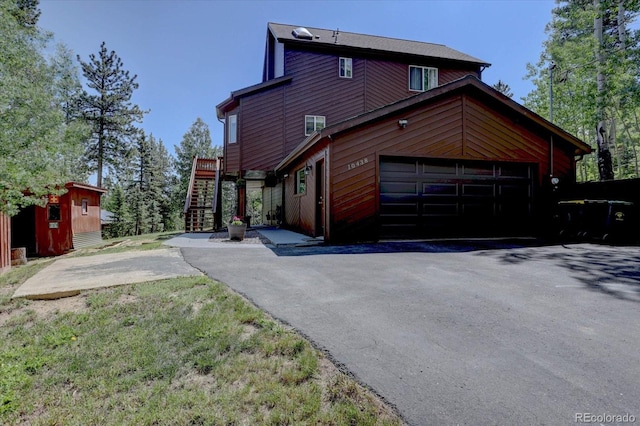 10438 Sunlight Ln, Conifer, CO 80433 - view of property exterior featuring a garage, driveway, and stairs