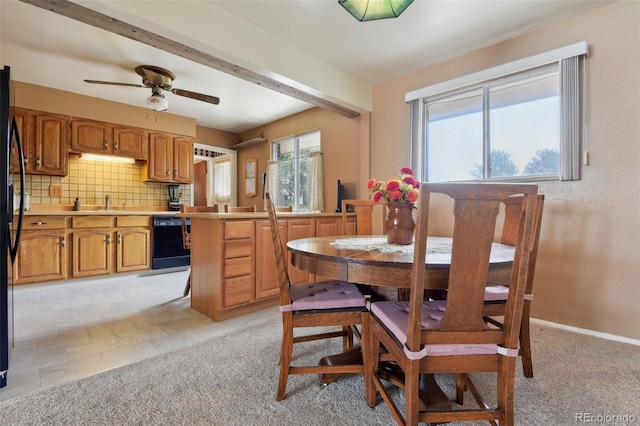 dining room featuring beamed ceiling, light carpet, baseboards, and a ceiling fan