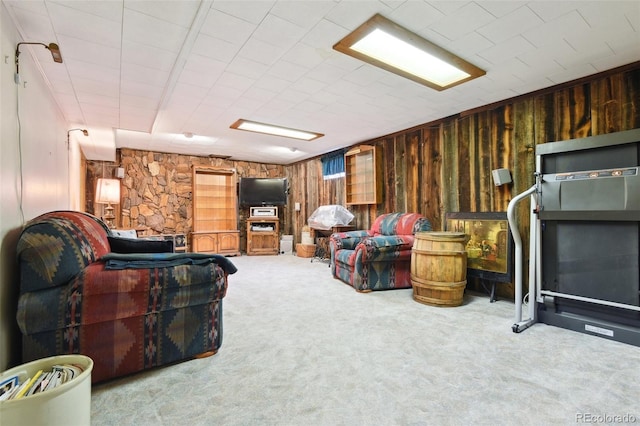 carpeted living room with wood walls