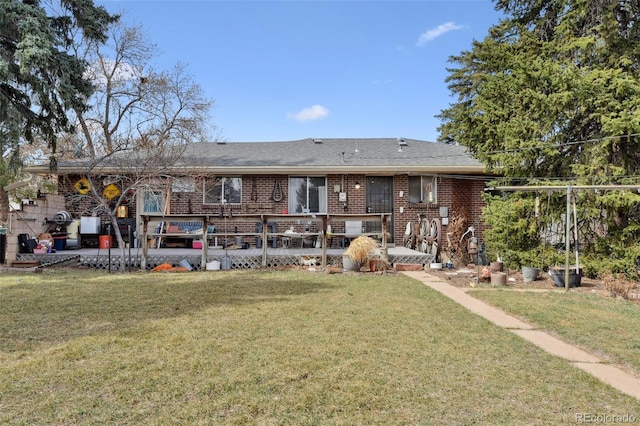 rear view of house featuring brick siding and a lawn