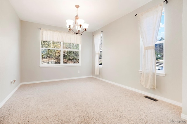 empty room featuring a chandelier, carpet floors, and a healthy amount of sunlight