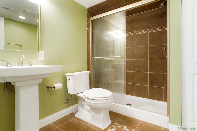 bathroom featuring tile patterned floors, a shower with shower door, and toilet