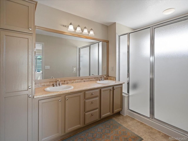 full bath featuring a stall shower, double vanity, tile patterned flooring, and decorative backsplash