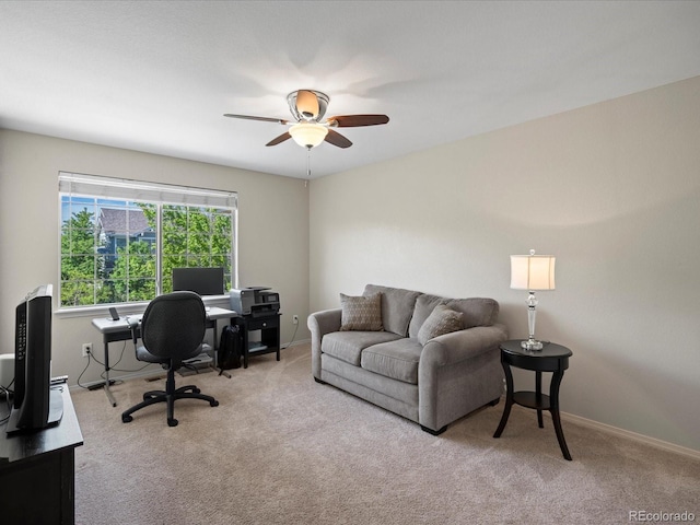 carpeted office with ceiling fan and baseboards