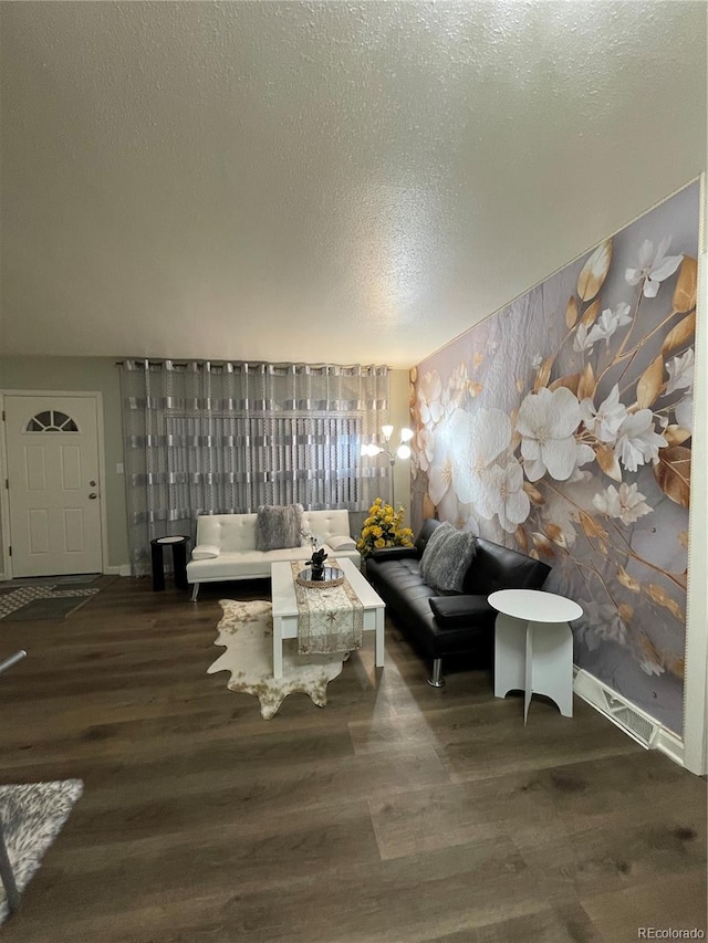 living room featuring dark wood-type flooring and a textured ceiling