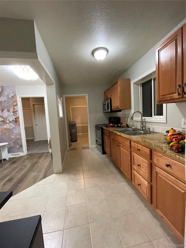 kitchen featuring light hardwood / wood-style floors, a textured ceiling, sink, and black electric range