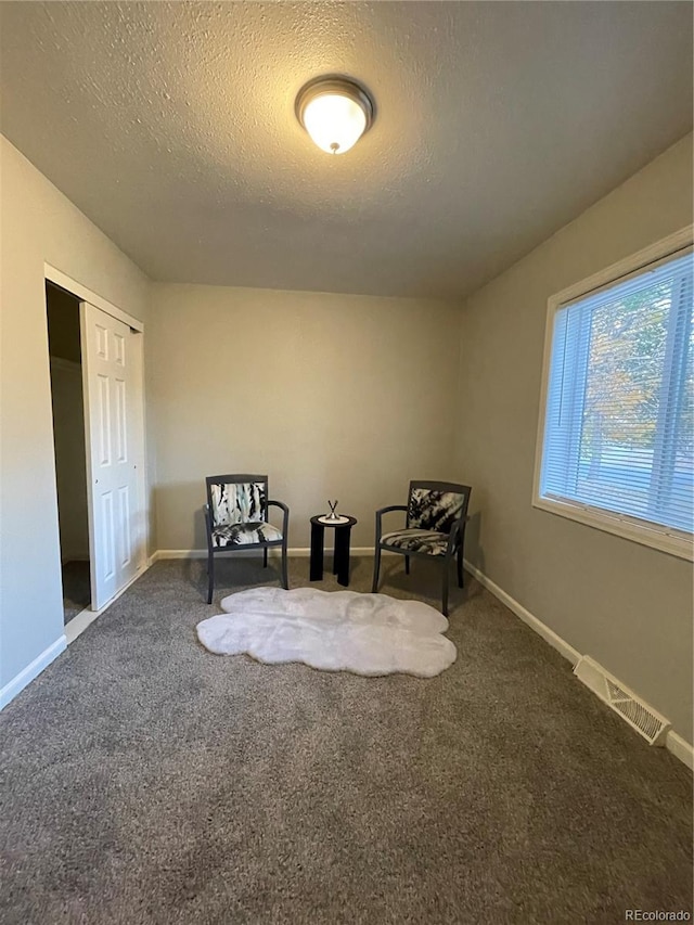 unfurnished room featuring carpet floors and a textured ceiling