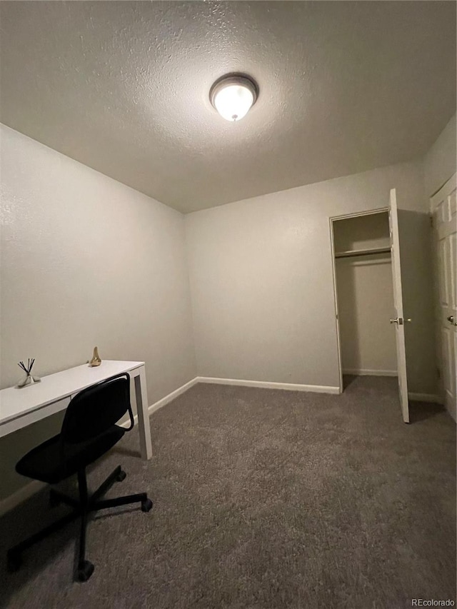 office with a textured ceiling and dark carpet