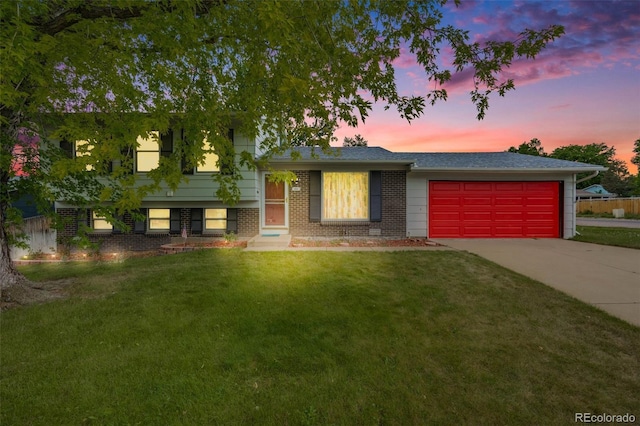 4511 S Braun Ct, Morrison, CO 80465 - tri-level home with an attached garage, driveway, a lawn, and brick siding