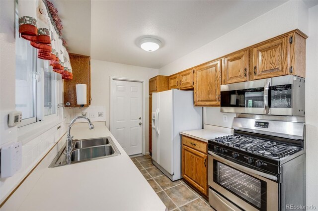 4511 S Braun Ct, Morrison, CO 80465 - kitchen with stainless steel appliances, light countertops, brown cabinets, and light tile patterned floors