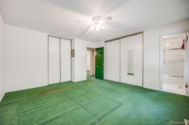 4511 S Braun Ct, Morrison, CO 80465 - unfurnished bedroom with multiple closets, carpet flooring, a textured ceiling, and ensuite bath