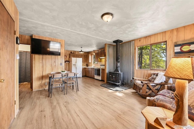 29 Deerfield Ln, Florissant, CO 80816 - living area with wooden walls, light wood-style floors, and a wood stove