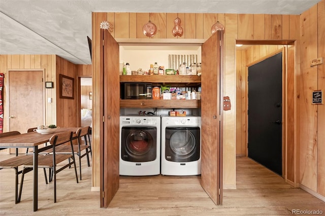 29 Deerfield Ln, Florissant, CO 80816 - washroom with washing machine and clothes dryer, light wood-style flooring, and wood walls