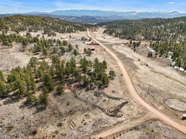 29 Deerfield Ln, Florissant, CO 80816 - aerial view of property and surrounding area with mountains, rural landscape, and a forest