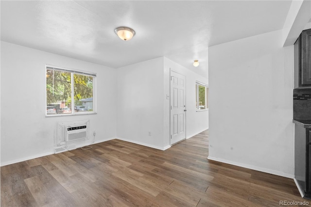 1235 S Benton St, Lakewood, CO 80232 - unfurnished living room with a fireplace, an AC wall unit, and wood finished floors