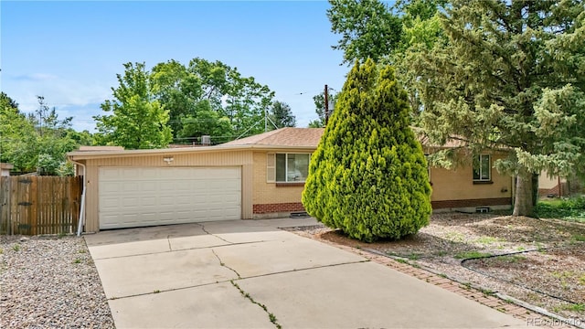 1235 S Benton St, Lakewood, CO 80232 - view of front of home with brick siding, an attached garage, and driveway