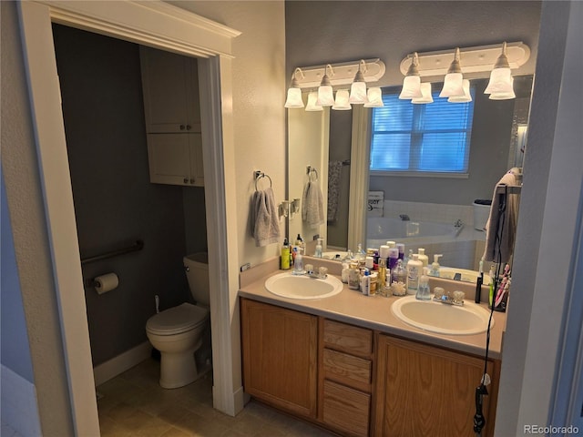 bathroom featuring tile patterned floors, vanity, toilet, and a bathing tub